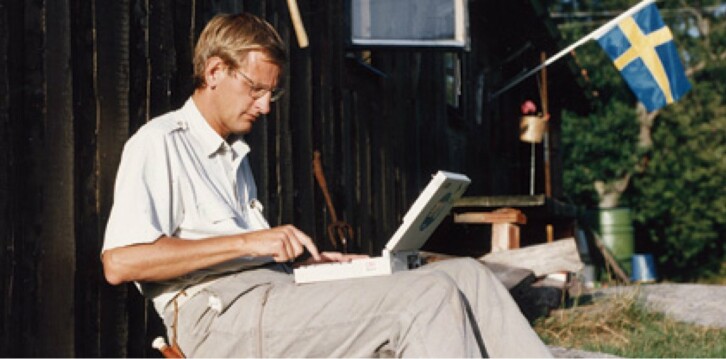 Carl Bildt utanför sommarstuga med bärbar dator, 1990-tal