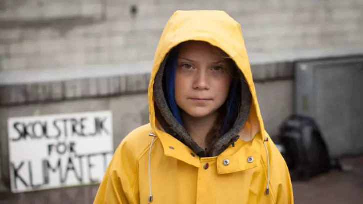 Porträtt av Greta Thunberg i regnjacka.